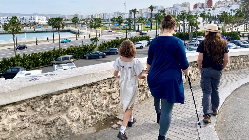 Mama and two kids walk from the medina toward the waterfront in Tangier, Morocco